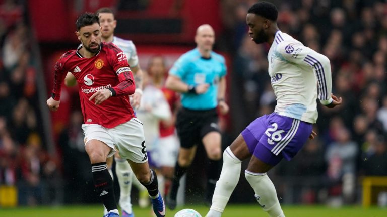 Aston Villa's Lamare Bogarde passes the ball in front of Manchester United's Bruno Fernandes during the Premiier League soccer match between Manchester United and Aston Villa in Manchester, England, Sunday, March 15, 2026. (AP Photo/Dave Thompson)