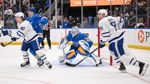 Justin Holl (4) and St. Louis Blues' Jordan Binnington (50) defend the net against Michael Pezzetta (61) and Toronto Maple Leafs' Dakota Joshua (81) during the third period of an NHL hockey game Saturday, March 28, 2026, in St. Louis. (Connor Hamilton/AP)