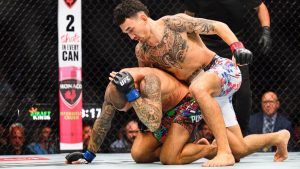 Max Holloway hits Dustin Poirier in a lightweight BMF Title fight at UFC 318 in New Orleans in 2025. (Ella Hall/AP)
