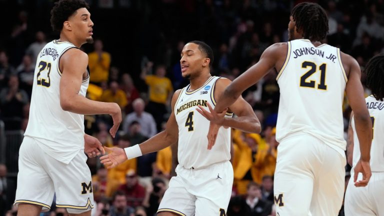 Michigan's Nimari Burnett (4) celebrates with teammates Yaxel Lendeborg (23) and Morez Johnson Jr. (21) during the second half in the Sweet 16 of the NCAA college basketball tournament against Alabama, Friday, March 27, 2026, in Chicago. (AP Photo/Nam Y. Huh)