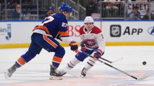 Montreal Canadiens' Cole Caufield (13) fights for control of the puck with New York Islanders' Anders Lee (27) during the second period of an NHL hockey game Thursday, March 20, 2025, in Elmont, N.Y. (Frank Franklin II/AP)