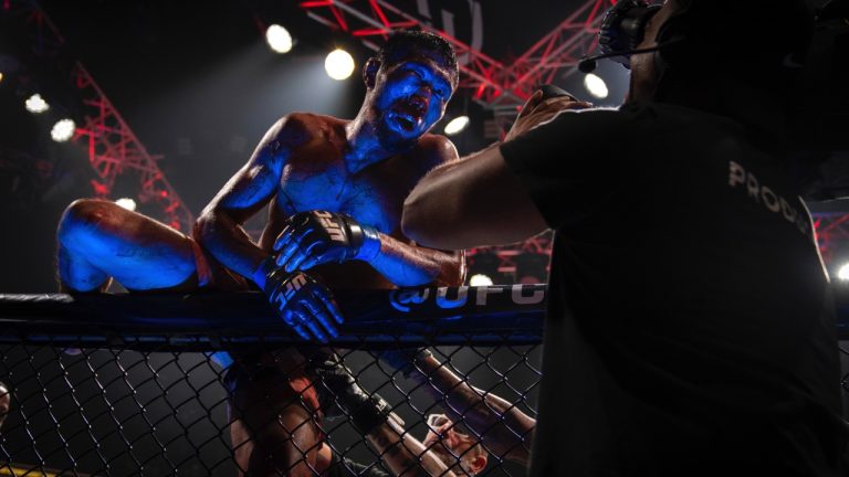Myktybek Orolbai climbs the cage after a UFC fight. (Altaf Qadri/AP)
