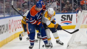 Nashville Predators' Matthew Wood (71) and Edmonton Oilers' Evan Bouchard (2) battle for the puck during first period NHL action in Edmonton on Sunday, March 15, 2026. (Jason Franson/CP)