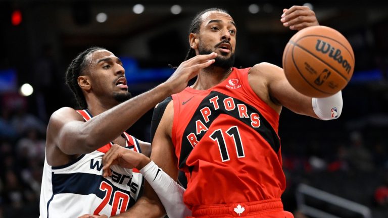 Washington Wizards center Alex Sarr (20) and Toronto Raptors center Olivier Sarr (11) vie for a rebound during the first half of a preseason NBA basketball game Sunday, Oct. 12, 2025, in Washington. (AP Photo/John McDonnell)