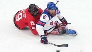 United States' Declan Farmer, right, challenges for the puck with Canada's Dominic Cozzolino during the ice hockey gold medal match between United States and Canada at the 2026 Winter Paralympics, in Milan, Italy, Sunday, March 15, 2026. (AP Photo/Antonio Calanni)