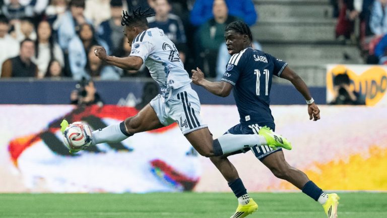 San Jose Earthquakes' DeJuan Jones (24) and Vancouver Whitecaps' Emmanuel Sabbi (11) vie for the ball during the first half of an MLS soccer match in Vancouver, on Saturday, March 21, 2026. (Ethan Cairns/CP)