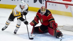 Pittsburgh Penguins centre Ben Kindel (81) chases the puck as it deflects off Ottawa Senators goaltender Linus Ullmark (35) during first period NHL action in Ottawa, Thursday, March 26, 2026. (Adrian Wyld/CP)