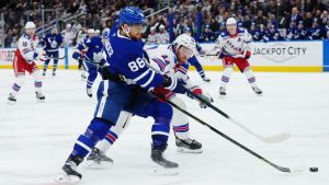 Toronto Maple Leafs' William Nylander (88) battles for the puck with New York Rangers' Vladislav Gavrikov (44) during second period NHL hockey action in Toronto on Thursday, October 16, 2025. (Nathan Denette/CP)