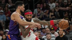 Toronto Raptors forward Brandon Ingram (3) shields the ball from Phoenix Suns guard Devin Booker during the second half of an NBA basketball game, Sunday, March 23, 2026, in Phoenix. (Rick Scuteri/AP)
