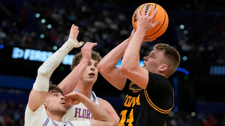 Iowa guard Bennett Stirtz (14) shoots over Florida guard Urban Klavzar and center Micah Handlogten during the first half in the second round of the NCAA college basketball tournament Sunday, March 22, 2026, in Tampa, Fla. (Chris O'Meara/AP)