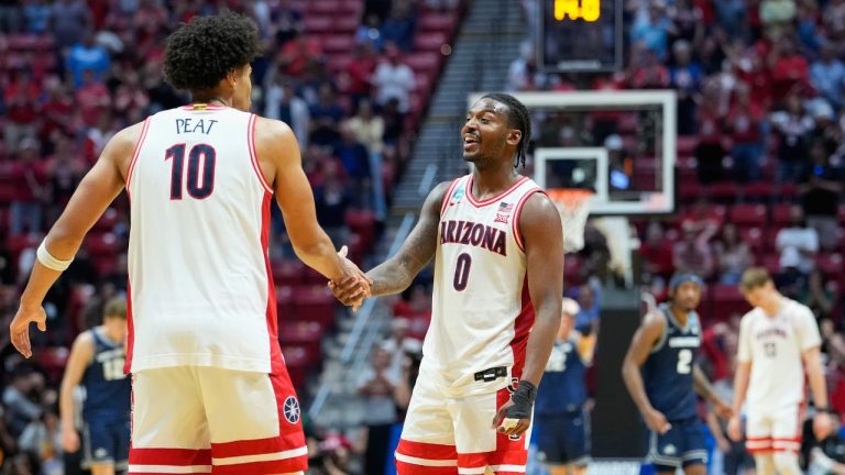Arizona forward Koa Peat (10), and Arizona guard Jaden Bradley (0) celebrate as their team leads Utah State during the second half of a game in the second round of the NCAA college basketball tournament Sunday, March 22, 2026, in San Diego. (AP Photo/Mark J. Terrill)
