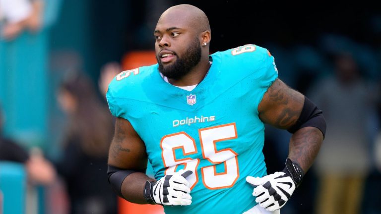 Miami Dolphins offensive lineman Robert Jones (65) runs onto the field during player introductions before an NFL football game against the San Francisco 49ers on Dec. 22, 2024, in Miami Gardens, Fla. (AP Photo/Doug Murray, File)