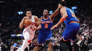 Toronto Raptors' Scottie Barnes (4) drives as New York Knicks' Og Anunoby (8) and Karl-Anthony Towns (32) defend during first half NBA basketball action in Toronto on Tuesday, March 3, 2026. THE CANADIAN PRESS/Nathan Denette