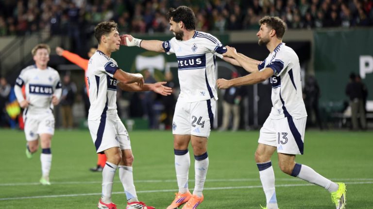 Vancouver Whitecaps forward Brian White, center, celebrates after scoring against the Portland Timbers with midfielder Sebastian Berhalter, left, and forward Thomas Müller, right, during the first half of an MLS soccer match, Saturday, March 7, 2026, in Portland, Ore. (AP Photo/Amanda Loman)