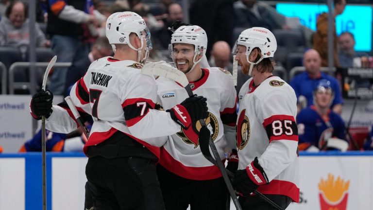 Ottawa Senators' Artem Zub, centre, celebrates with teammates Brady Tkachuk and Jake Sanderson after scoring an empty-net goal during the third period of an NHL game against the New York Islanders, Tuesday, Jan. 14, 2025, in Elmont, N.Y. (AP Photo/Frank Franklin II)
