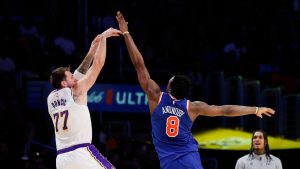 Los Angeles Lakers guard Luka Doncic (77) shoots a 3-pointer while being guarded by New York Knicks forward Og Anunoby (8) during the second half of an NBA basketball game, Sunday, March 8, 2026, in Los Angeles. (AP Photo/Caroline Brehman)
