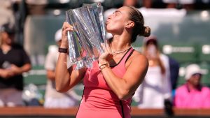 Aryna Sabalenka, of Belarus, kisses the winner's trophy after defeating Elena Rybakina, of Kazakhstan, to win the BNP Paribas Open tennis tournament Sunday, March 15, 2026, in Indian Wells, Calif. (AP Photo/Mark J. Terrill)