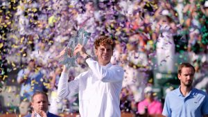 Jannik Sinner, of Italy, middle, holds the winner's trophy after defeating Daniil Medvedev, of Russia, right, during a final match at the BNP Paribas Open tennis tournament, Sunday, March 15, 2026, in Indian Wells, Calif. (AP Photo/Mark J. Terrill)