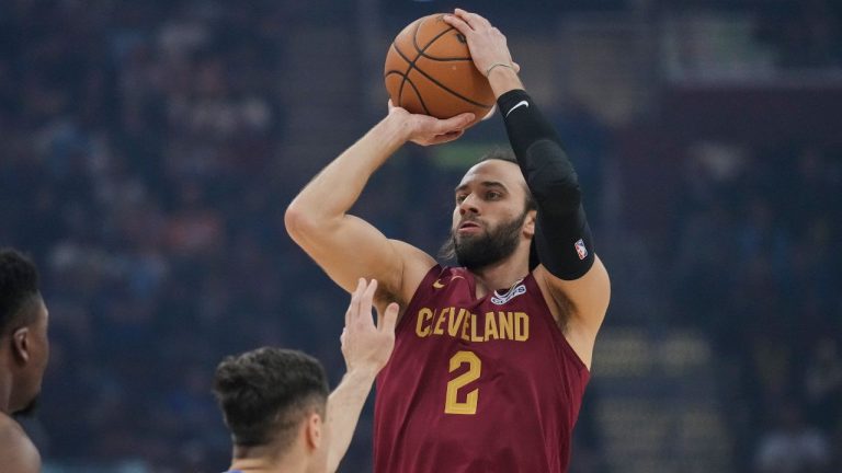 Cleveland Cavaliers guard Max Strus (2) shoots as Dallas Mavericks guard John Poulakidas, left, defends in the first half of an NBA basketball game in Cleveland, Sunday, March 15, 2026. (AP Photo/Sue Ogrocki)