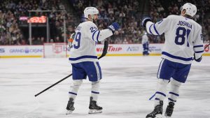Toronto Maple Leafs center Benoit-Olivier Groulx, left, celebrates with center Daokta Joshua (81) after scoring a goal during the second period of an NHL hockey game against the Minnesota Wild, Sunday, March 15, 2026, in St. Paul, Minn. (AP Photo/Abbie Parr)