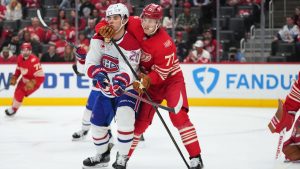 Detroit Red Wings defenseman Simon Edvinsson (77) defends Montreal Canadiens left wing Juraj Slafkovsk˝ (20) in the third period of an NHL hockey game Thursday, Oct. 9, 2025, in Detroit. (AP Photo/Paul Sancya)