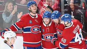Montreal Canadiens' Cole Caufield (13) celebrates his third goal against the New York Islanders with teammates Juraj Slafkovsky (20) Ivan Demidov (93) and Lane Hutson (48) during third NHL hockey action in Montreal, Saturday, March 21, 2026. THE CANADIAN PRESS/Graham Hughes