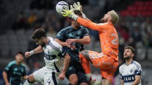 Seattle Sounders goalkeeper Stefan Frei, front right, collides with teammate Jackson Ragen, centre, as he vies for the ball against Vancouver Whitecaps' Brian White (24) while Thomas Muller, back right, watches during the second half of a CONCACAF Champions Cup soccer match, in Vancouver, on Thursday, March 12, 2026. (Darryl Dyck/CP)