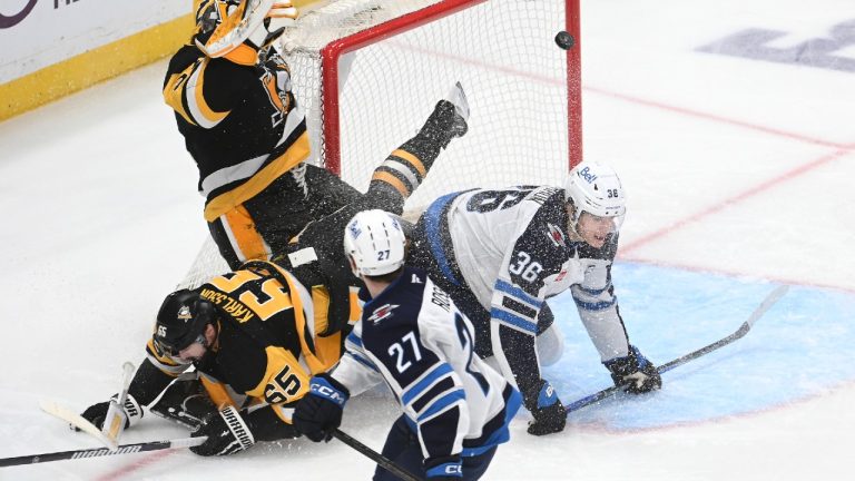 Winnipeg Jets center Morgan Barron (36) scores on Pittsburgh Penguins goalie Arturs Silovs (37) while crashing into defenseman Erik Karlsson (65) as right wing Isak Rosen (27) looks on during the first period in an NHL hockey game, Saturday, March 21, 2026, in Pittsburgh. (Philip G. Pavely/AP)