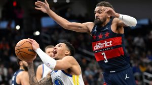 Golden State Warriors guard Will Richard, left, looks to shoot against Washington Wizards guard Trae Young, right, during the first half of an NBA basketball game, Monday, March 16, 2026, in Washington. (AP Photo/John McDonnell)