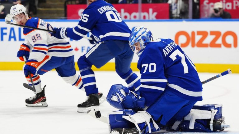 Toronto Maple Leafs goaltender Artur Akhtyamov (70) makes a save as Edmonton Oilers' Andrew Mangiapane (88) and Maple Leafs' Oliver Ekman-Larsson (95) battle during third period NHL hockey action in Toronto on Saturday, Dec. 13, 2025. (Frank Gunn/CP)