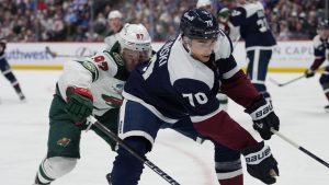 Colorado Avalanche defenseman Sam Malinski (70) and Minnesota Wild left wing Kirill Kaprizov (97) pursue the puck in the second period of an NHL hockey game Sunday, March 8, 2026, in Denver. (David Zalubowski/AP Photo)