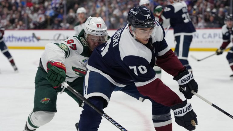 Colorado Avalanche defenseman Sam Malinski (70) and Minnesota Wild left wing Kirill Kaprizov (97) pursue the puck in the second period of an NHL hockey game Sunday, March 8, 2026, in Denver. (David Zalubowski/AP Photo)