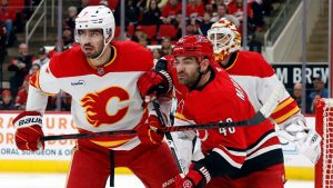 Carolina Hurricanes' Jordan Martinook tangles with Calgary Flames' Kevin Bahl during the second period of an NHL game in Raleigh, N.C., Sunday, Nov. 30, 2025. (AP/Karl DeBlaker)