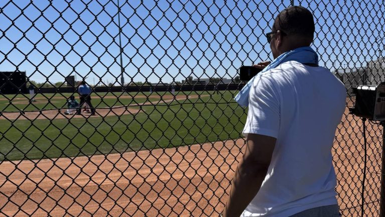 MIke Batiste looks behind the cage as his son, Mike Batiste Jr., plays a baseball game (Michael Grange/Sportsnet)