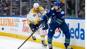 Nashville Predators' Steven Stamkos (91) and Vancouver Canucks' Marcus Pettersson (29) vie for the puck during the first period of an NHL game in Vancouver, on Thursday, March 12, 2026. (Ethan Cairns/THE CANADIAN PRESS)