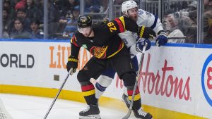 Vancouver Canucks' Marcus Pettersson (29) and Tampa Bay Lightning's Jake Guentzel (59) vie for the puck during the first period of an NHL hockey game, in Vancouver, on Thursday, March 19, 2026. (Darryl Dyck/CP)