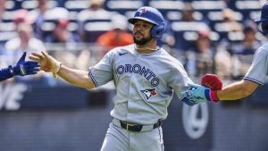Toronto Blue Jays' Jonatan Clase, centre, is greeted by Myles Straw, left, and Ernie Clement (22) after scoring in the ninth inning of a baseball game against the Cleveland Guardians in Cleveland, Thursday, June 26, 2025. (Sue Ogrocki/AP)