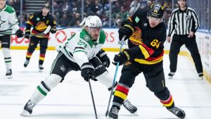 Dallas Stars' Roope Hintz (24) and Vancouver Canucks' David Kampf (64) vie for the puck during the third period of an NHL hockey game in Vancouver, on Thursday, November 20, 2025. (Ethan Cairns/CP)