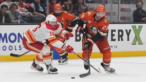 Anaheim Ducks left wing Jeffrey Viel (28) and Calgary Flames center Morgan Frost battle for the puck during the third period of an NHL hockey game Sunday, March 1, 2026, in Anaheim, Calif. (Gregory Bull/AP)