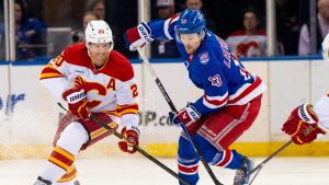 New York Rangers left wing Alexis Lafrenière (13) and Calgary Flames left wing Blake Coleman (20) battle for the puck during the second period of an NHL hockey game, Tuesday, March 10, 2026, in New York. (Angelina Katsanis/AP)