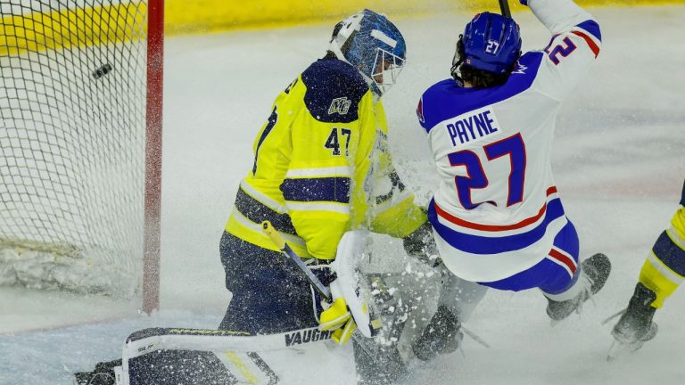 Merrimack goalie Max Lundgren (47) deflects a shot of Umass Lowell defenseman Dominic Payne (27) wide of the net during the first period of an NCAA hockey game on Friday, Oct. 3, 2025, in Lowell, Mass. (Greg M. Cooper/AP)