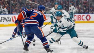 San Jose Sharks' Macklin Celebrini (71) tries to get past Edmonton Oilers' Evan Bouchard (2) during first period NHL action, in Edmonton on Tuesday March 17, 2026. (Jason Franson/CP)