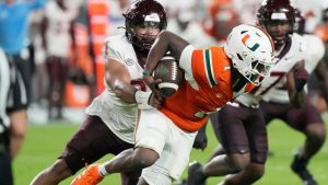 Virginia Tech defensive lineman Wilfried Pene (91) grabs Miami quarterback Cam Ward (1) during the first half of an NCAA college football game, Friday, Sept. 27, 2024, in Miami Gardens, Fla. (Marta Lavandier/AP Photo)