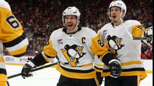 Pittsburgh Penguins' Sidney Crosby (87) comes to congratulate teammate Erik Karlsson, left, on his goal with Rickard Rakell, right, during the third period of an NHL hockey game against the Carolina Hurricanes in Raleigh, N.C., Wednesday, March 18, 2026. (Karl DeBlaker/AP)