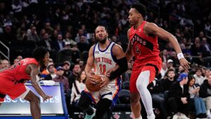 New York Knicks guard Jalen Brunson (11) drives past Toronto Raptors forward Scottie Barnes (4) during the second half of an NBA basketball game Sunday, Nov. 30, 2025, in New York. (Yuki Iwamura/AP)