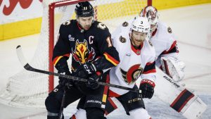 Ottawa Senators' Nick Jensen, right, checks Calgary Flames' Mikael Backlund during first period NHL action in Calgary on Thursday, March 5, 2026. (THE CANADIAN PRESS/Jeff McIntosh)