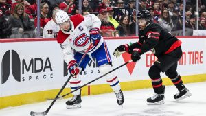 Montreal Canadiens' Nick Suzuki (14) tries to maintain possession of the puck while being pressured by Ottawa Senators' Artem Zub (2) during first period NHL hockey action in Ottawa, on Wednesday, March 11, 2026. (Spencer Colby/CP)