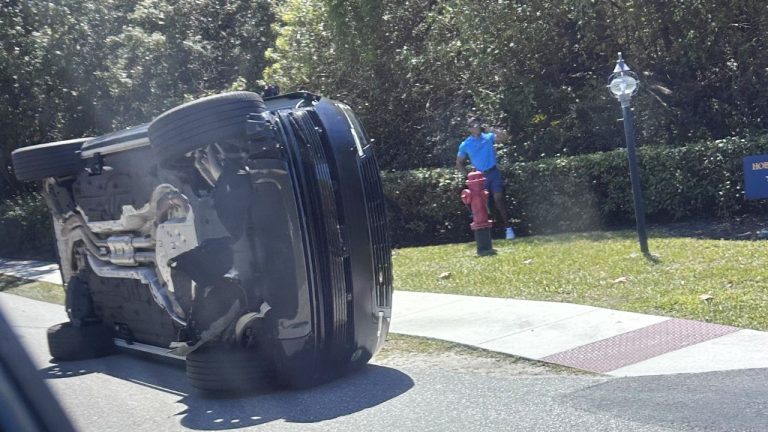 Golfer Tiger Woods stands by his overturned vehicle in Jupiter Island, Fla., on Friday, March 27, 2026. (Jason Oteri/AP)