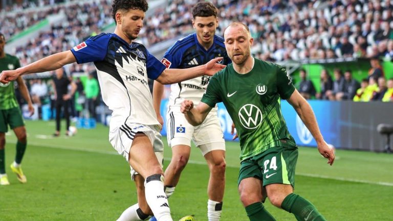 Wolfsburg's Christian Eriksen, right, and Hamburger's Daniel Elfadli battle for the ball during their German Bundesliga match in Wolfsburg, Germany, Saturday, March 7, 2026. (Andreas Gora/dpa via AP)