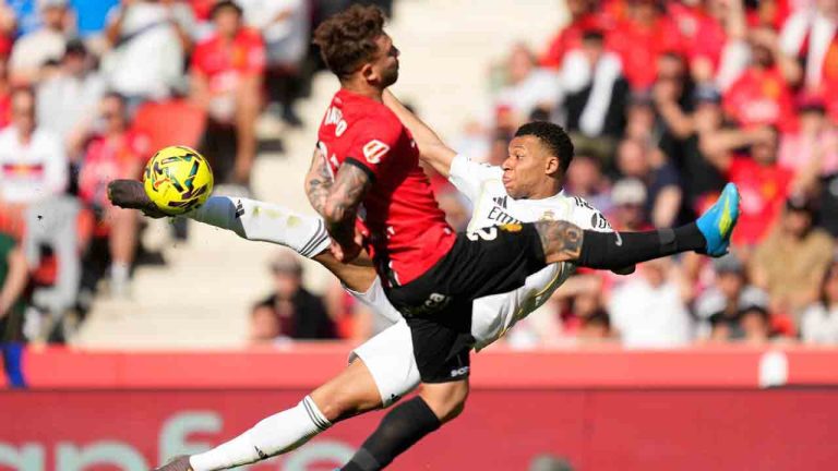 Real Madrid's Kylian Mbappe shoots by Mallorca's Pablo Maffeo during a La Liga soccer match between Mallorca and Real Madrid in Palma de Mallorca, Spain, Saturday, April 4, 2026. (Jose Breton/AP)